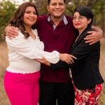 A joyful family trio hugging in a natural outdoor setting, symbolizing love and togetherness.